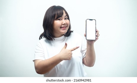 Portrait Of A Chubby Asian Teenage Woman Holding A Smartphone On A White Screen.