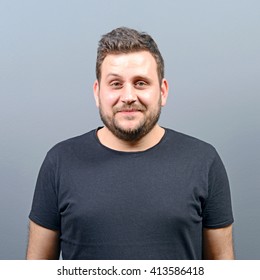 Portrait Of Chubby Young Man Against Gray Background