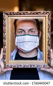 Portrait Of Clear Boy With Surgical Mask Dressed Casual Standing In The Living Room At Home, Shown Through The Frame Of A Picture