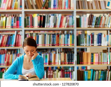 Portrait Of Clever Student With Open Book Reading It In College Library