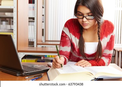 Portrait Of Clever Student Reading Book In College Library