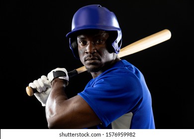 Portrait Close Up Of An African American Male Baseball Player, A Hitter, Wearing A Team Uniform And A Helmet, Ready To Swing A Baseball Bat 