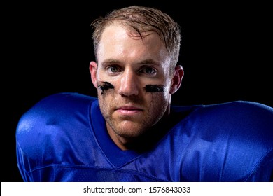 Portrait Close Up Of A Caucasian Male American Football Player Wearing A Team Uniform With Shoulder Pads And Lines Of Eye Black Under His Eyes