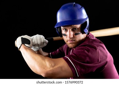 Portrait Close Up Of A Caucasian Male Baseball Player, A Hitter, Wearing A Team Uniform And A Helmet, With Stripes Of Eye Black Under His Eyes, Ready To Swing A Baseball Bat 