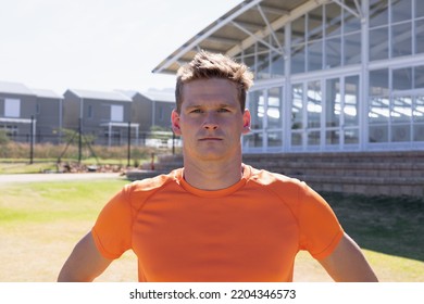 Portrait Close Up Of A Caucasian Male Runner Training At A Sports Field, Wearing An Orange T Shirt, Looking Straight To Camera