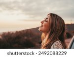 Portrait close up of face of one young beautiful woman smiling with closed eyes enjoying freedom sensation emotion. Teen cheerful young female outdoors having fun.