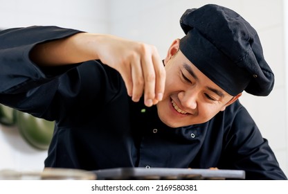 Portrait, Close Up Handsome Asian Japanese Professional Chef Wearing Black Uniform, Smiling With Happiness, Cooking And Decorating Dish. Hotel Or Restaurant Service Concept