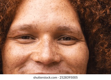 Portrait close up of happy biracial man with red curly hair and freckles smiling. Free time, lifestyle and wellbeing, unaltered. - Powered by Shutterstock