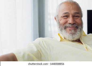 Portrait Close Up Of Senior Mixed Race Man Smiling Inside Room. Authentic Senior Retired Life Concept