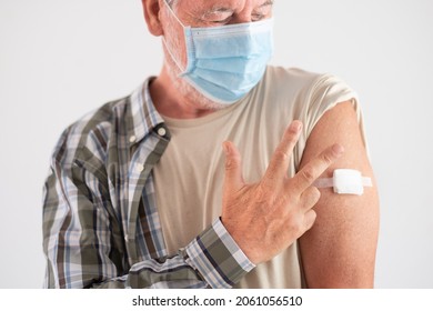 Portrait Close Up studio shot of old caucasian senior man patient wearing face mask showing with fingers number three as booster third doses of covid-19 vaccine. Against new omicron variant - Shutterstock ID 2061056510