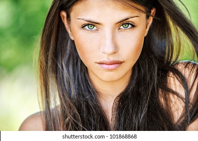 Portrait close up of young beautiful woman, on green background summer nature.