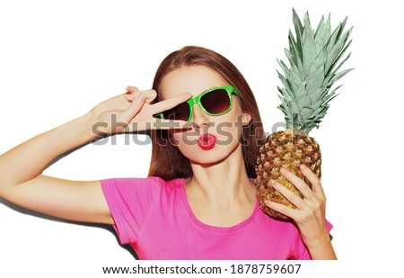 Portrait close up of young woman with pineapple blowing lips wearing a sunglasses isolated on a white background