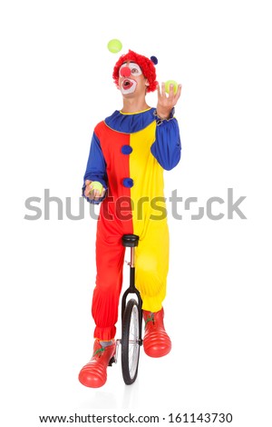 Portrait Of A Clown Juggling With Balls On Unicycle Over White Background