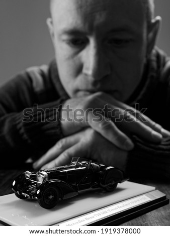 portrait of a collector of retro car models on a black background 2021