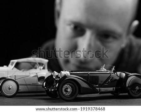 portrait of a collector of retro car models on a black background 2021