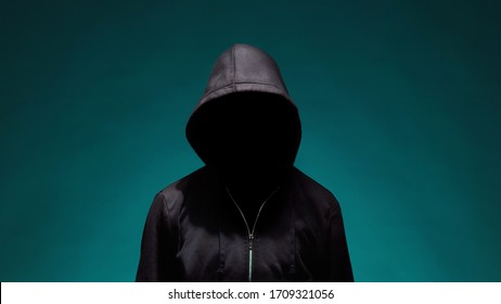 Portrait of computer hacker in hoodie. Obscured dark face. Data thief, internet fraud, darknet and cyber security . - Shutterstock ID 1709321056