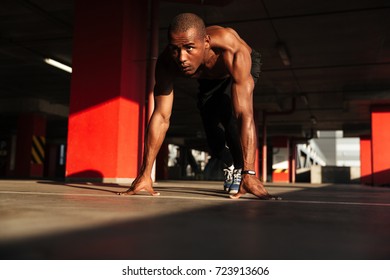 Portrait Of A Concentrated Young Half Naked African Sportsman Getting Ready To Run Indoors