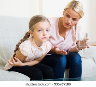 Portrait Of Concerned Woman And Child With Abdominal Pains