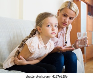 Portrait Of Concerned Woman And Child With Abdominal Pains