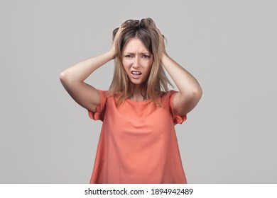 Portrait Of Concerned, Worried And Anxious Blond Girl, Grab Head And Panicking, Staring Alarmed, Feel Scared And Nervous, Dont Know What Do. Studio Shot, Gray Background