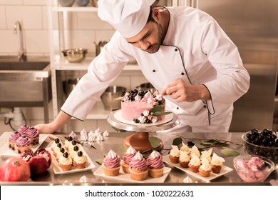 portrait of confectioner decorating cake in restaurant kitchen