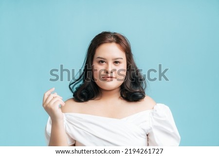 Portrait Confidence beautiful Asian woman plus size on isolate light blue studio background. Young female chubby confident concept.