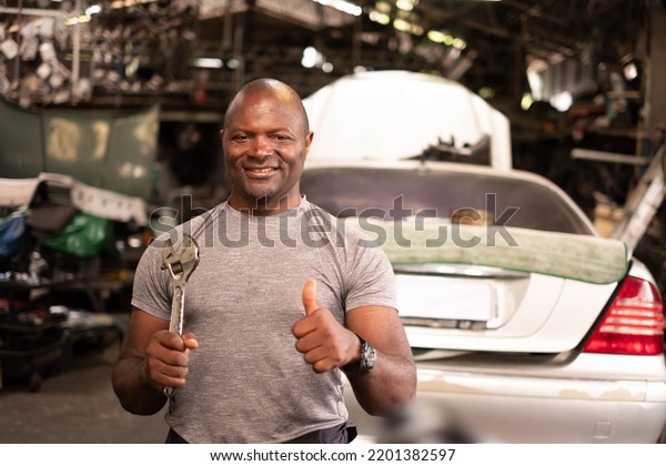 Portrait of a confident African American male\
Mechanic in the\
garage.