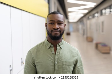 Portrait Of Confident African American Young Male Teacher Standing In School Corridor. Unaltered, Education, Occupation And School Concept.