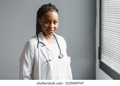 Portrait confident African female doctor medical professional writing patient notes isolated on hospital clinic hallway windows background. Positive face expression - Powered by Shutterstock