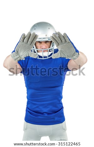 Portrait confident American football player defending against white background