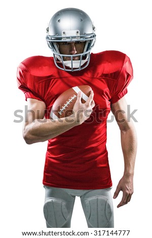 Portrait of confident American football player in red jersey holding ball on white background