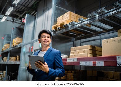 Portrait of a confident Asian businessman investor in Asia standing in a large warehouse and warehouse environment, factory, distribution, business owner and investment idea, industry, warehousing. - Powered by Shutterstock