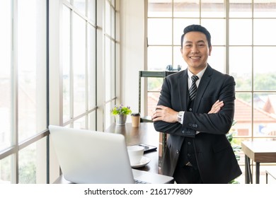 Portrait of confident Asian executive business man wear suite at the workspace office. Happy Asian business man with laptop computer and background office - Shutterstock ID 2161779809