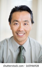 Portrait Of Confident Asian Male Cancer Specialist Smiling In Hospital