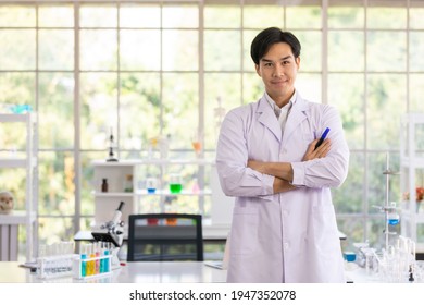 Portrait Of Confident Asian Man Researcher Or Scientist Medical Doctor Wearing Protection Glasses Standing Cross Arms In Laboratory. Concept Thinking For Medical