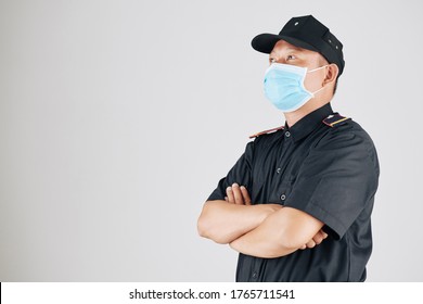 Portrait Of Confident Asian Policeman In Medical Mask Folding Arms And Looking Away