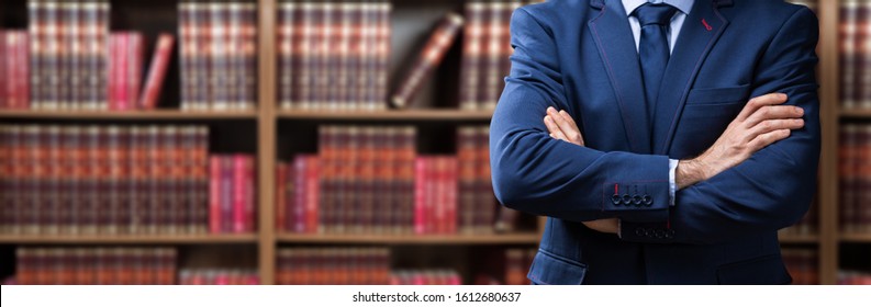 Portrait Of Confident Attorney Standing Arms Crossed Against Bookshelf In Office - Powered by Shutterstock