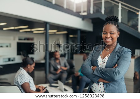 Portrait of a confident black businesswoman with all african american team in the background