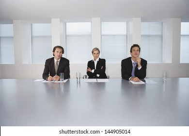 Portrait of confident business people sitting at conference table