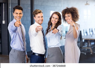 Portrait Of Confident Business Team Smiling And Pointing Their Fingers Forward In Office