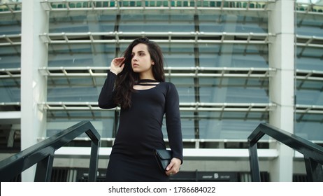 Portrait Confident Business Woman Touching Hair At Street. Sexy Woman Entrepreneur Walking Downstairs Outside. Attractive Woman Looking Away In Black Dress At Street.