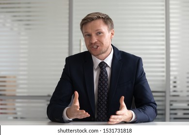 Portrait confident businessman coach wearing suit looking at camera and talking, making video call, mentor coach tutor recording webinar, online course, hr manager holding distance job interview - Powered by Shutterstock