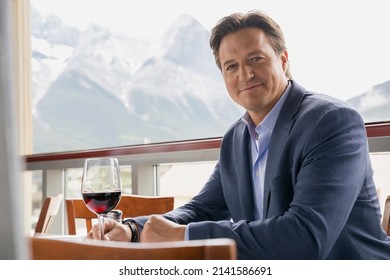 Portrait of confident businessman drinking wine on balcony - Powered by Shutterstock