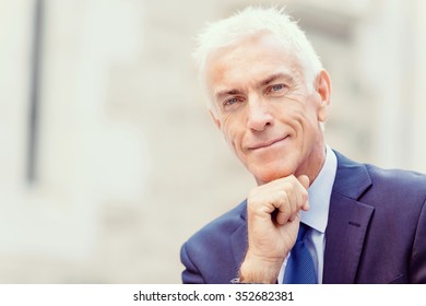 Portrait of confident businessman in suit outdoors - Shutterstock ID 352682381
