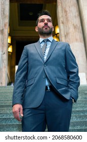 Portrait Of A Confident Businessman Walking Down The Stairs In An Ancient Building