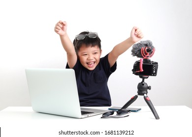 Portrait of confident and creative Asian child blogger talking on camera in a studio, he make video blog. Online influencer vlogger children boy social media live steaming concept.