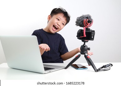 Portrait Of Confident And Creative Asian Child Blogger Talking On Camera In A Studio, He Make Video Blog. Online Influencer Vlogger Children Boy Social Media Live Steaming Concept.