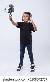 Portrait Of Confident And Creative Asian Child Blogger Talking On Camera In A Studio. Online Influencer Vlogger Children Boy Social Media Live Streaming Concept.