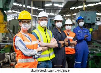 Portrait of confident engineer woman. Diverse multiethnic worker wearing surgical mask in manufacturing factory on day covid-19 virus pandemic. New normal, epidemic prevention. Selective focused