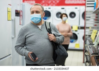 Portrait Of A Confident European Man In A Protective Mask Who Came Shopping At An Electronics And Home Appliance Store During ..the Pandemic